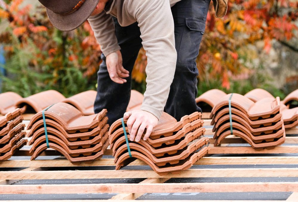 Worker on  Renovation Roof Covering It with Tiles Using Hammer — Goonellabah Roof Tilers In Ballina, NSW