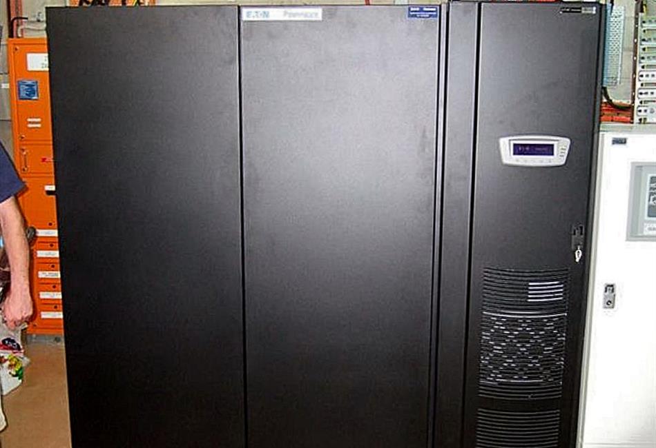 a man standing next to a large black cabinet with a digital display