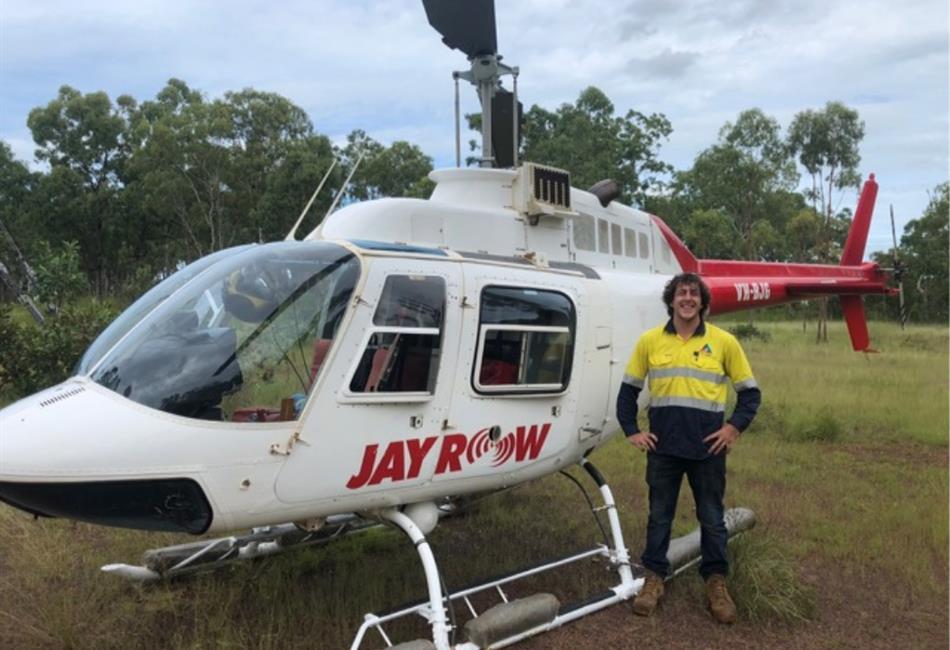 a man is standing in front of a jay row helicopter .