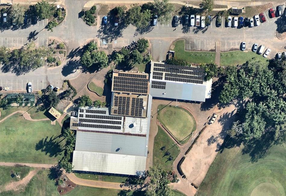 an aerial view of a building with solar panels on the roof