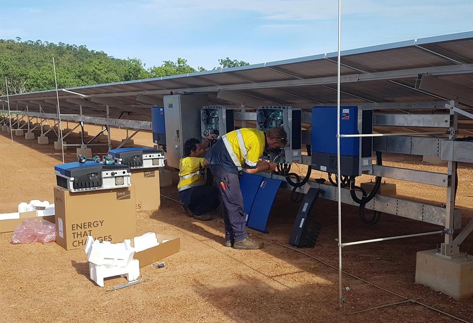 a group of men are working on a solar farm .