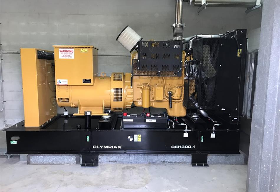a large yellow and black generator is sitting in a room .