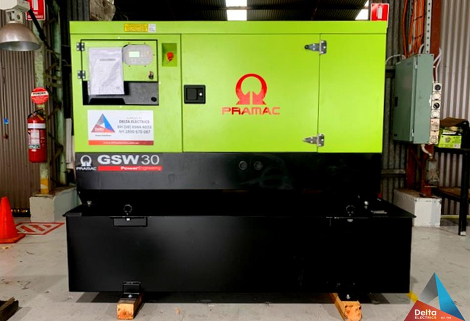 a green and black gsw30 generator is sitting in a warehouse .