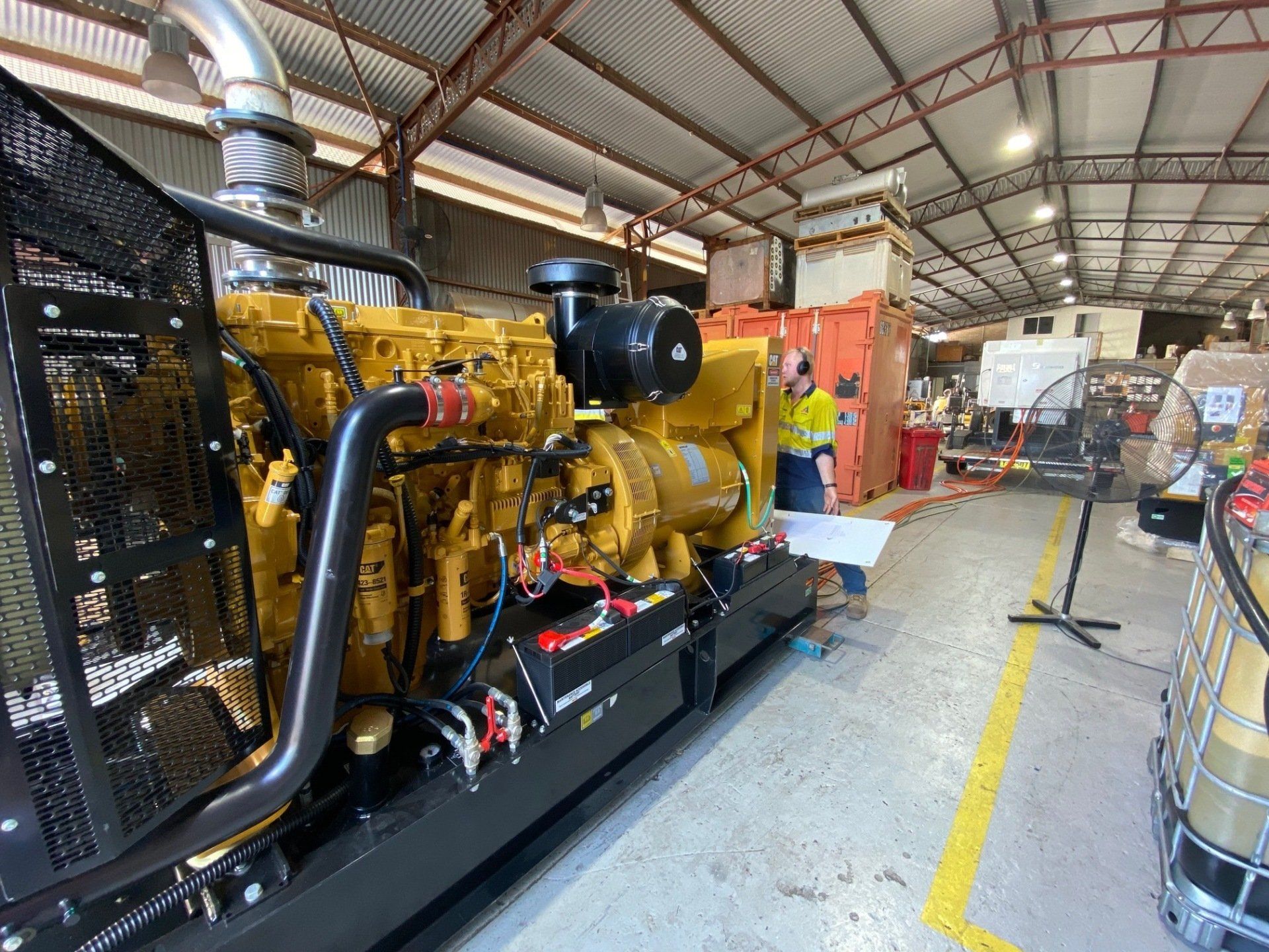a large yellow engine is sitting in a warehouse .