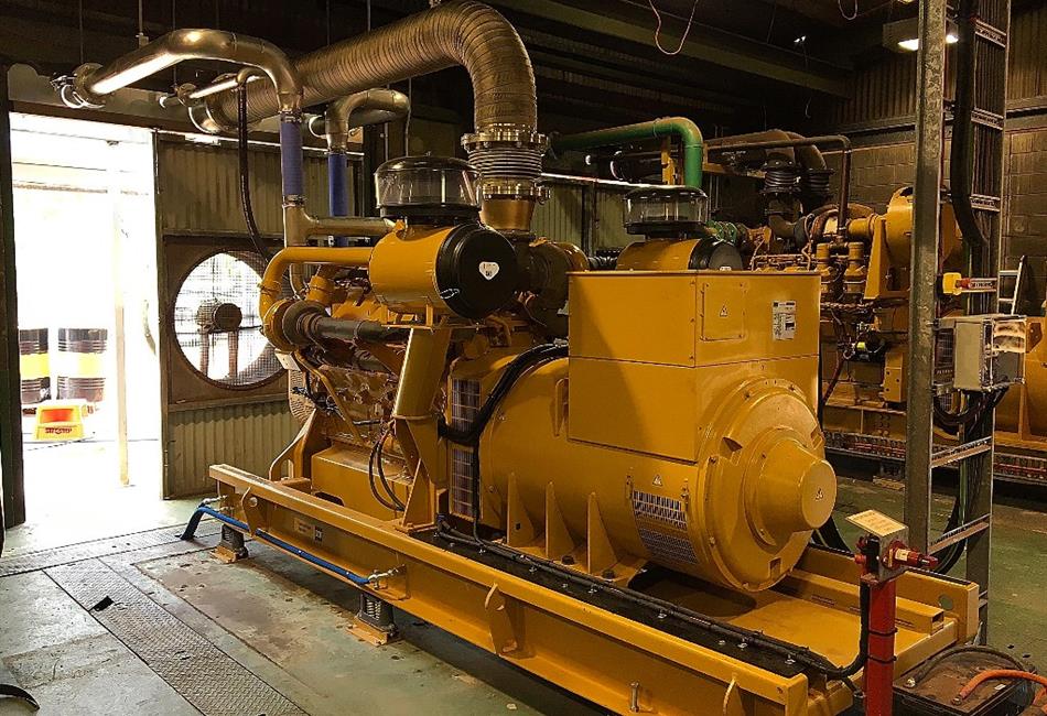a large yellow generator is sitting inside of a building .