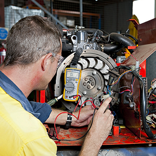 a man is working on an engine with a multimeter
