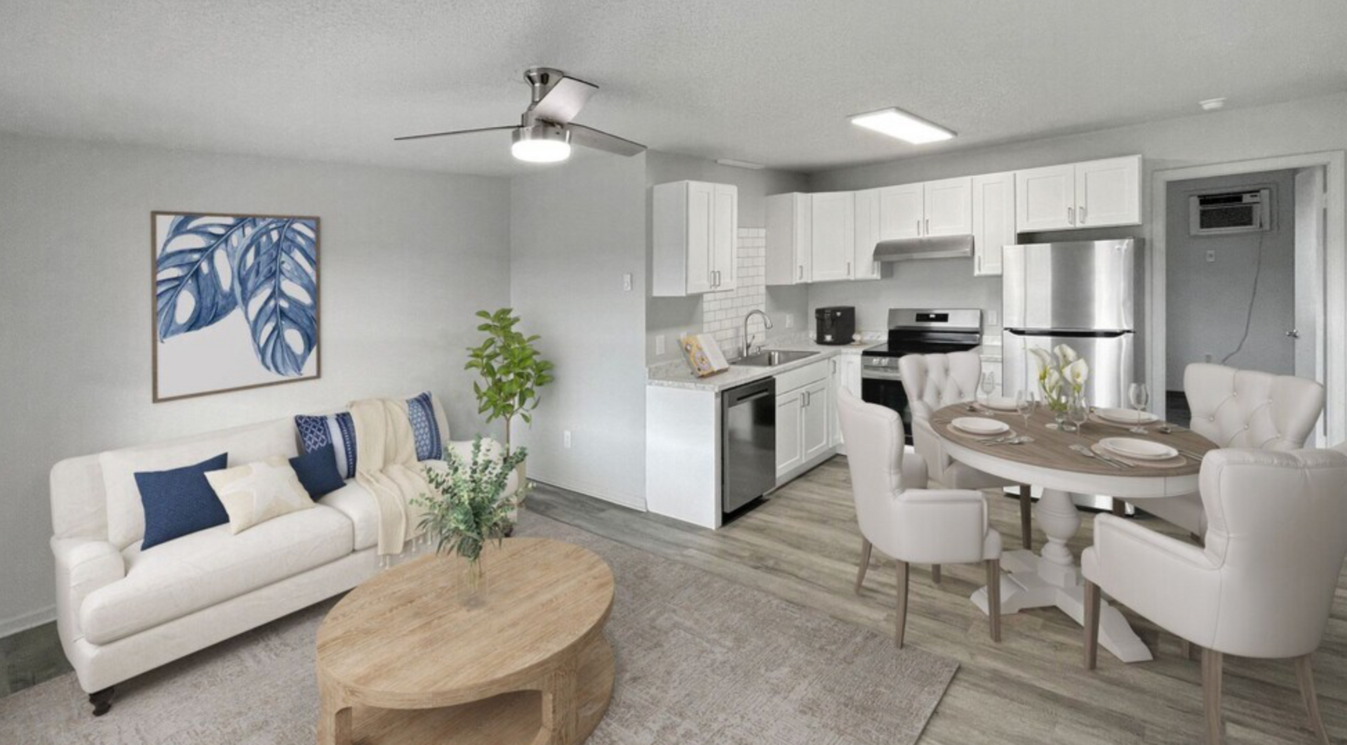 A living room with a couch , table , chairs and a ceiling fan.
