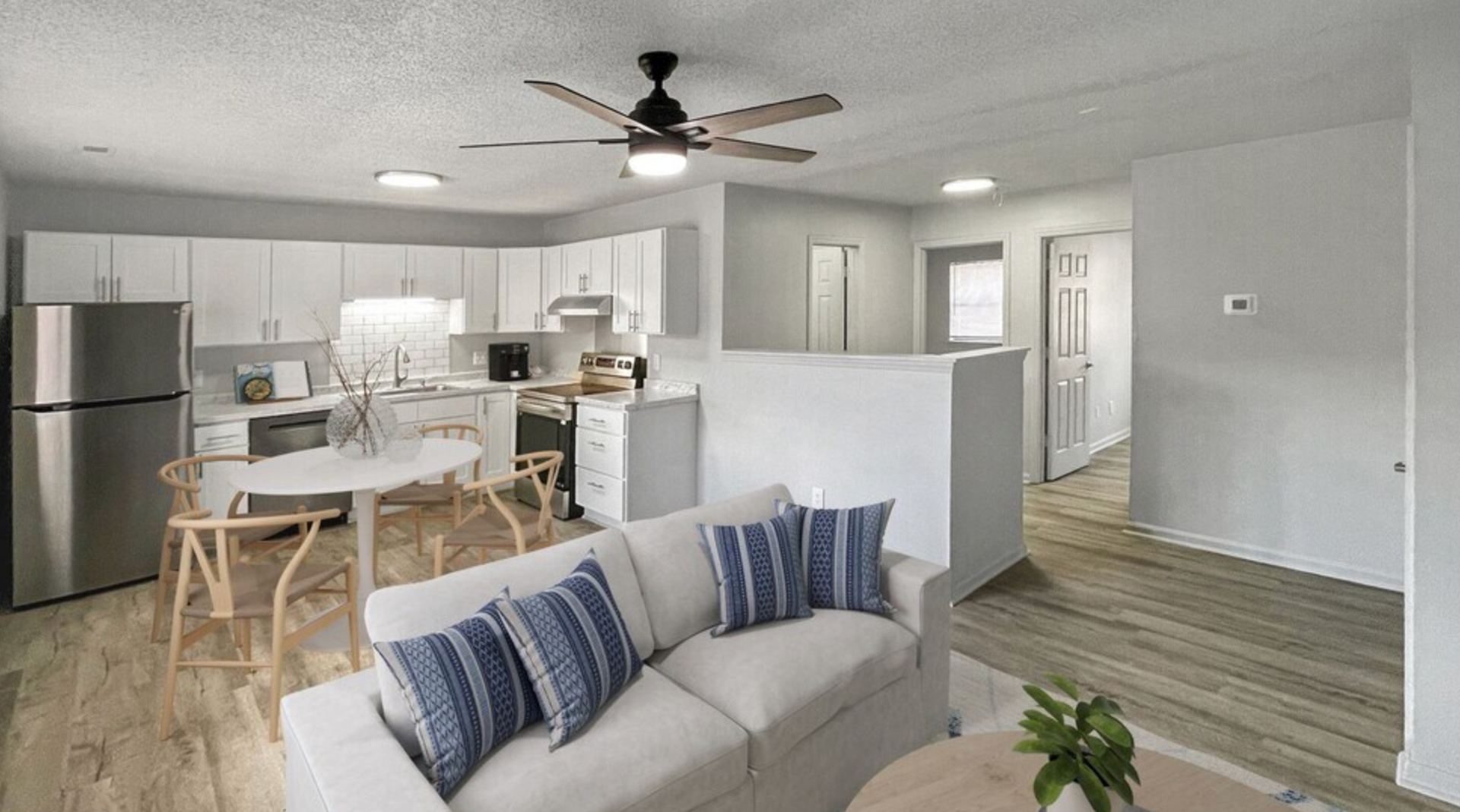 A living room with a couch , table and ceiling fan.