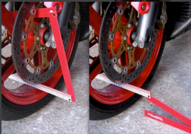 A motorcycle wheel is being measured with a red ruler