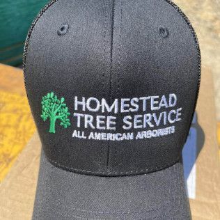 a black baseball cap that says homestead tree service all american arborists