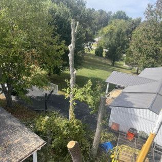 an aerial view of a tree being cut down in front of a house .