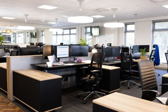 Office cleaners mopping and tidying a bright workspace with desks and plants Office cleaners mopping and tidying a bright workspace with desks and plants