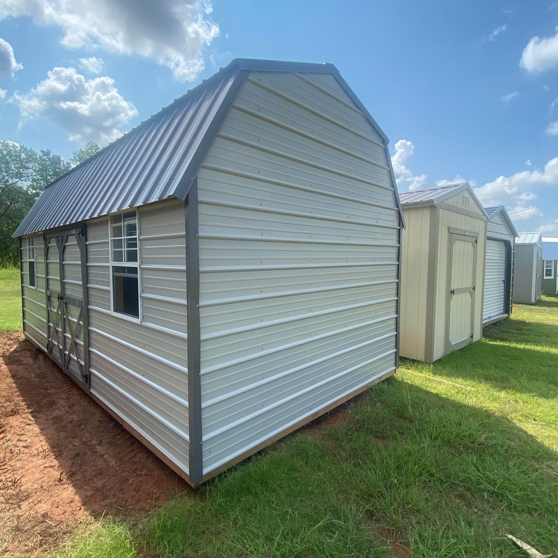 A Ash Gray shed with a Charcoal roof and Charcoal Trim is sitting in the middle of a grassy field.