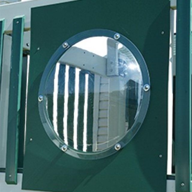 Una pared verde con una ventana redonda