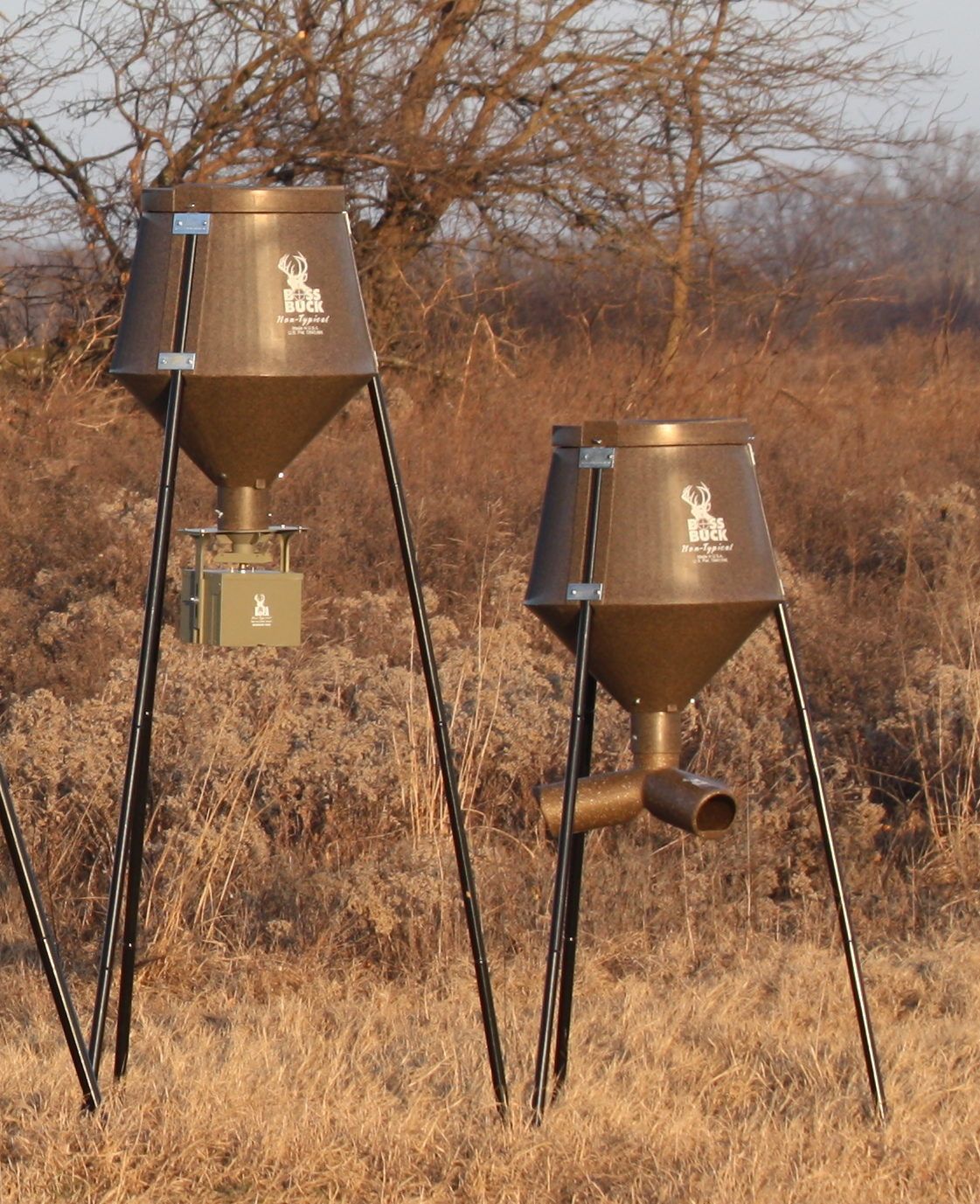 two buck feeders are sitting in a field
