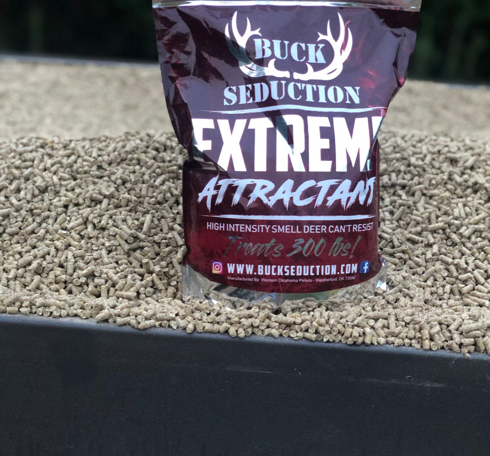 A bag of buck seduction extreme attractant sitting on top of a pile of pellets