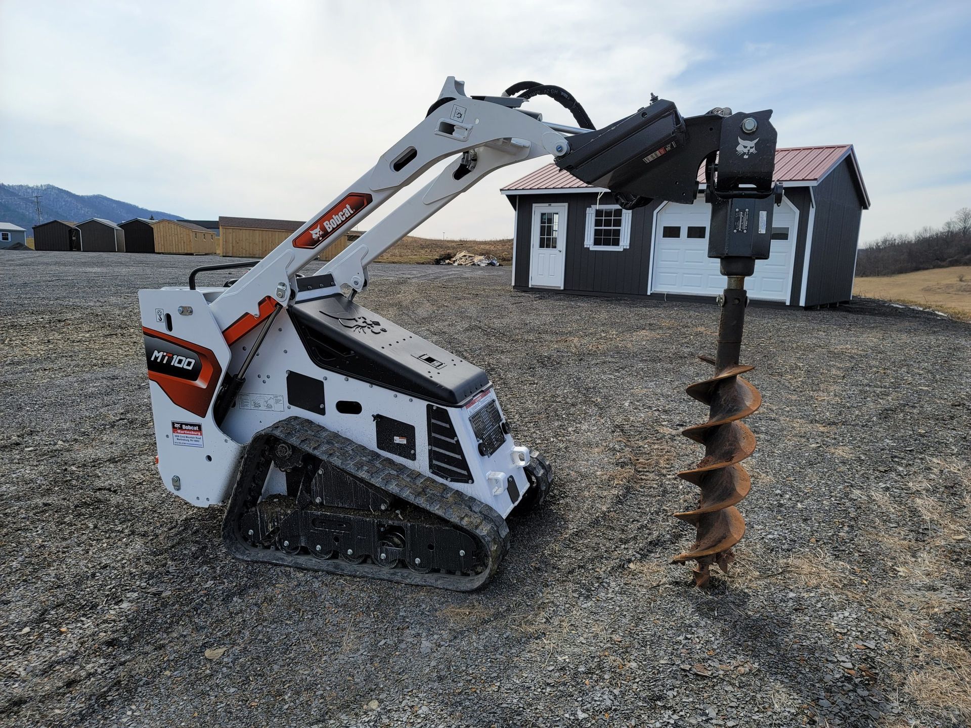 a man is driving a bobcat tractor carrying logs