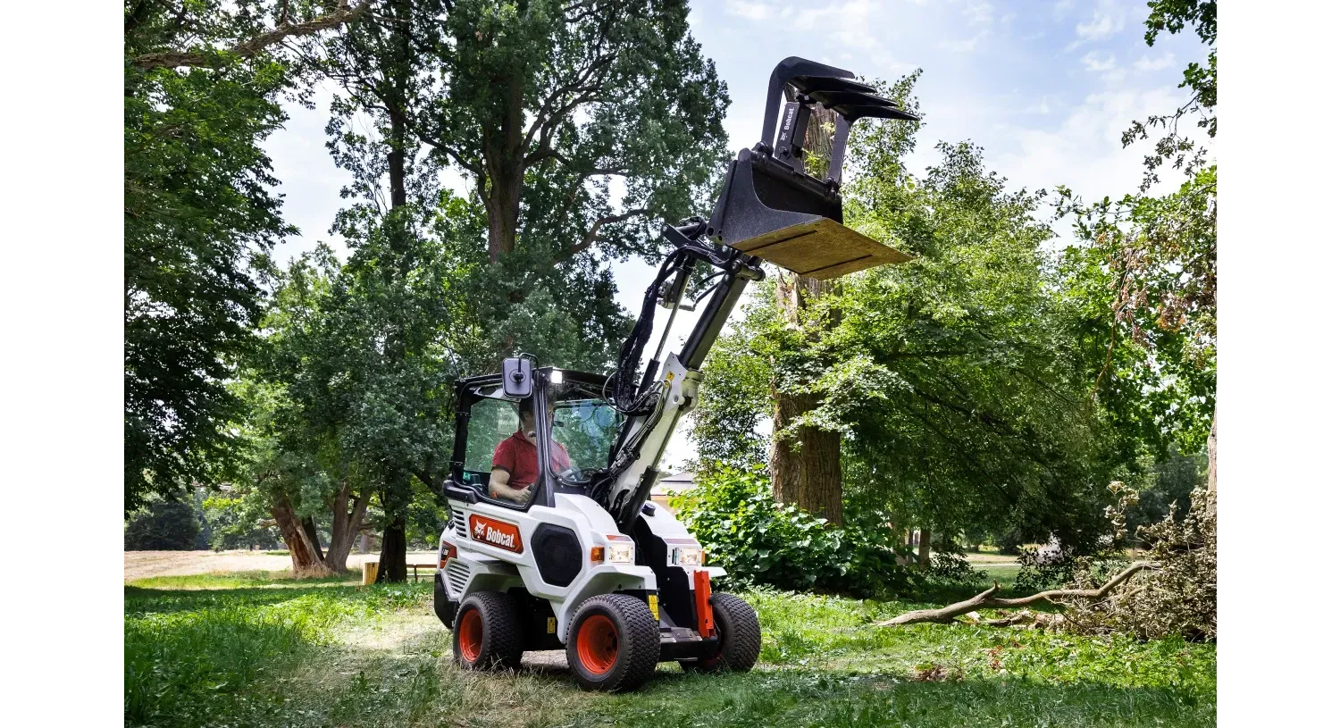 a man is driving a bobcat tractor in a park