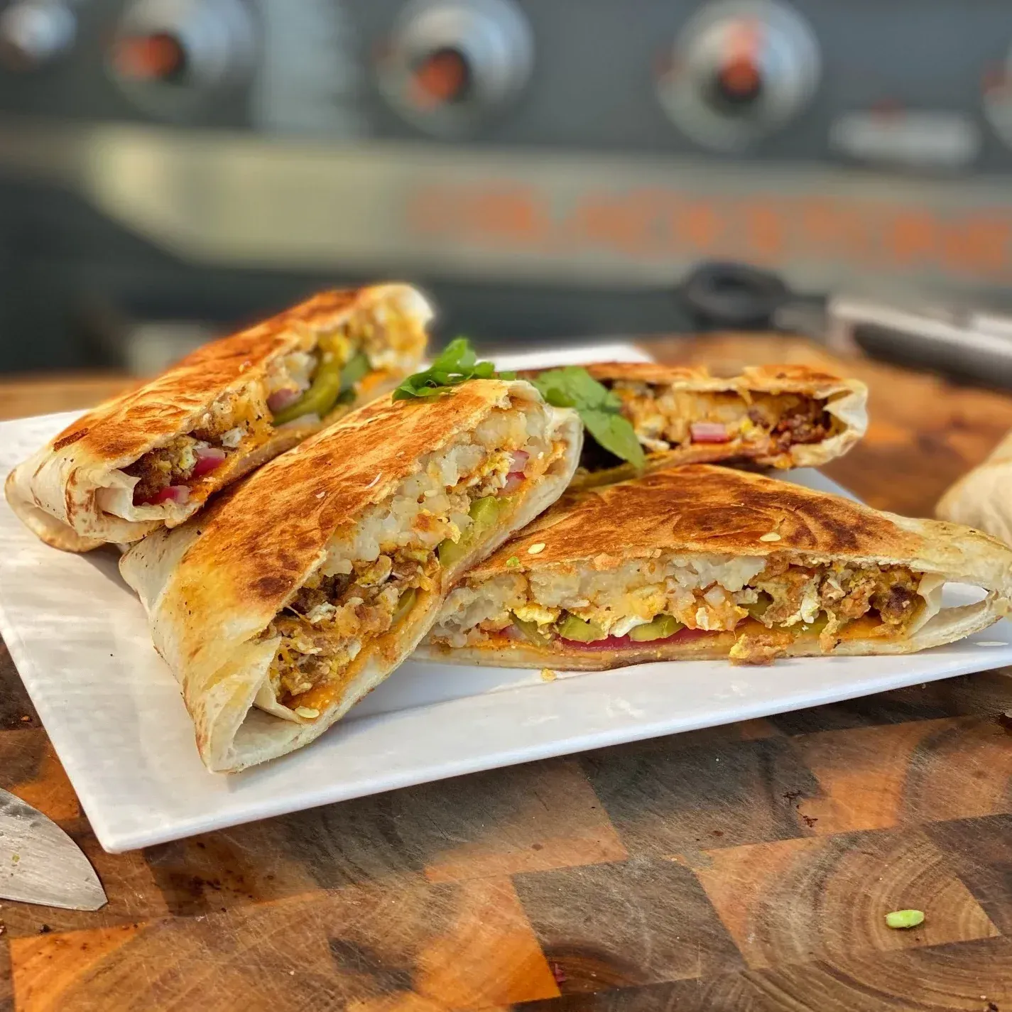 A white plate topped with three quesadillas on a wooden table.