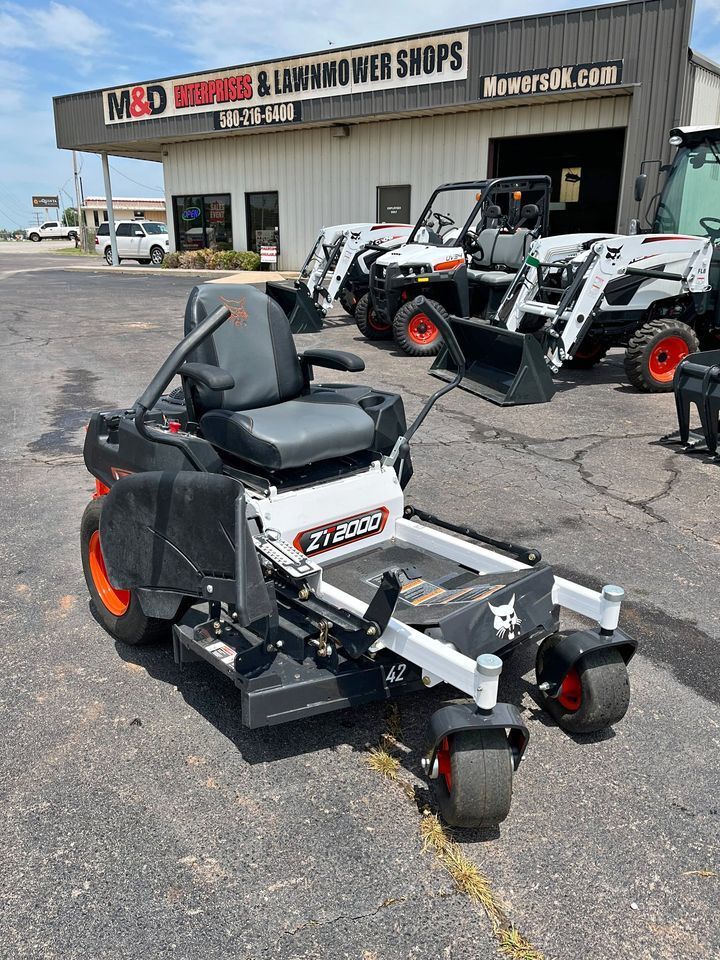 A bobcat zero turn mower is parked in front of a lawn mower shop.