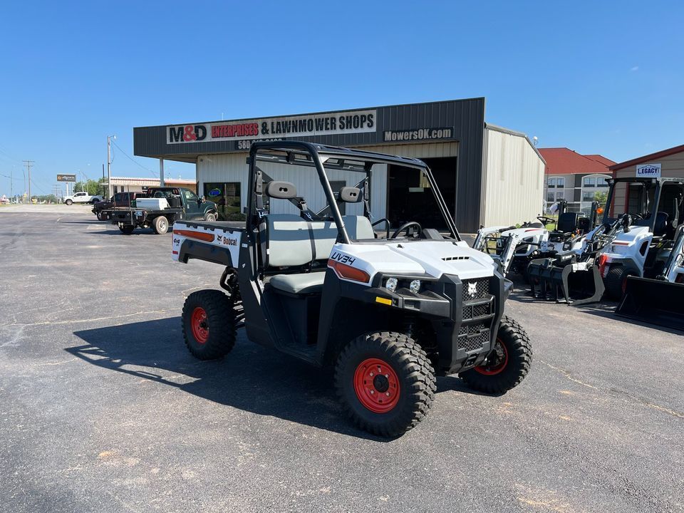 A bobcat utility vehicle is parked in front of a building.