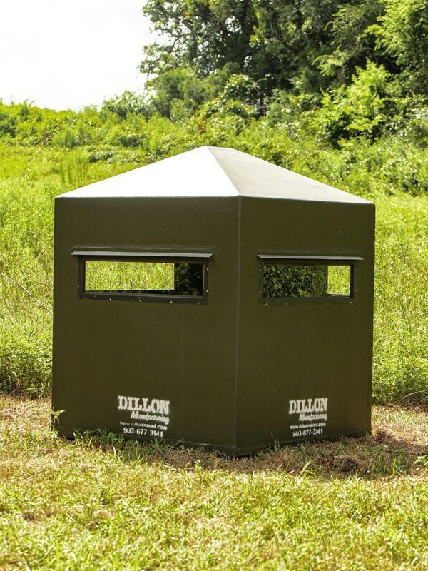 a hunting blind made by dillon manufacturing is sitting in the middle of a grassy field .