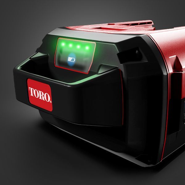 a black and red toro battery with a green light