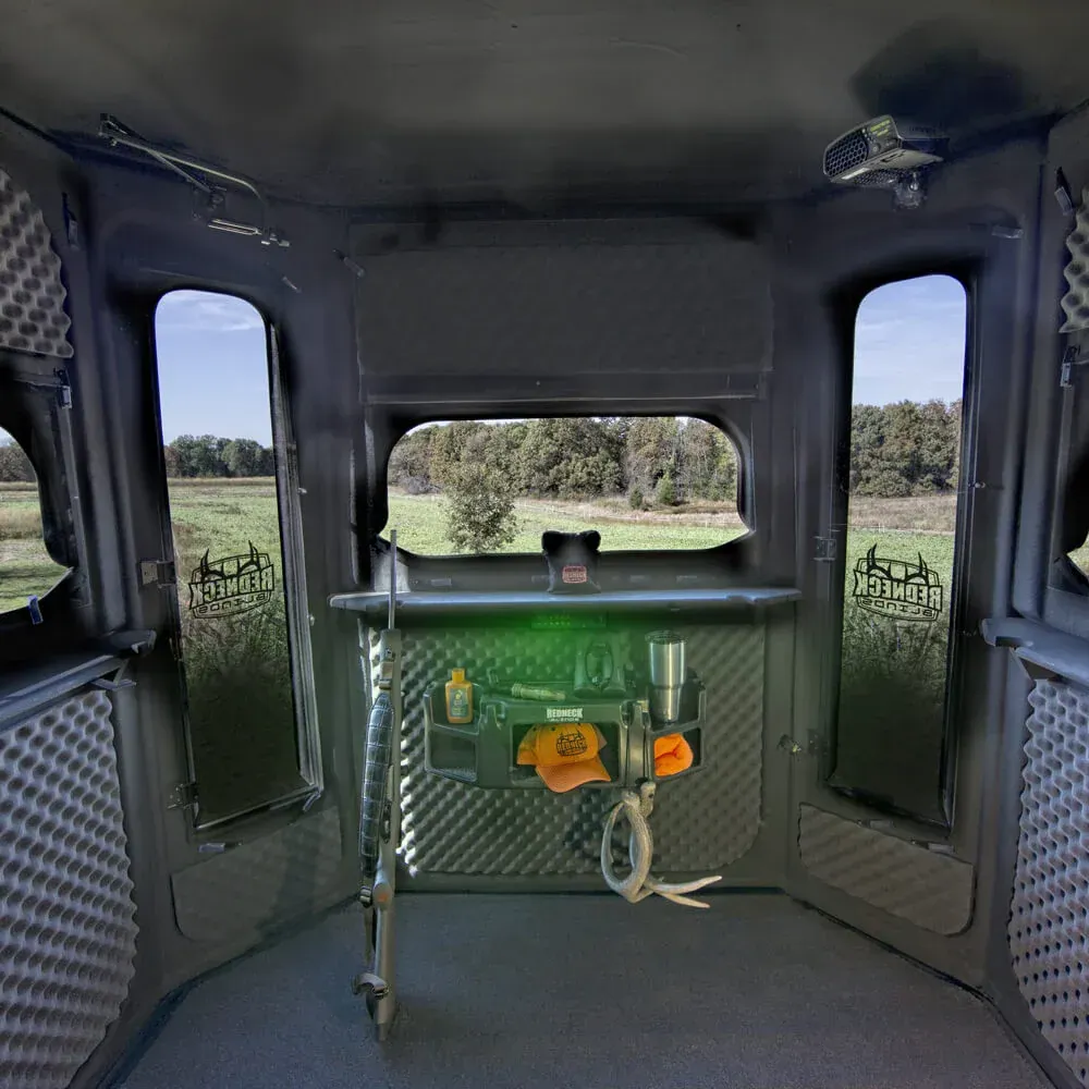 The inside of a deer blind  with a telephone on the wall