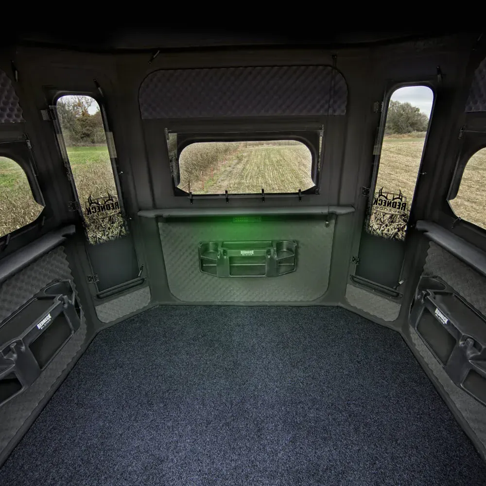 The inside of a hunting blind with a field in the background.