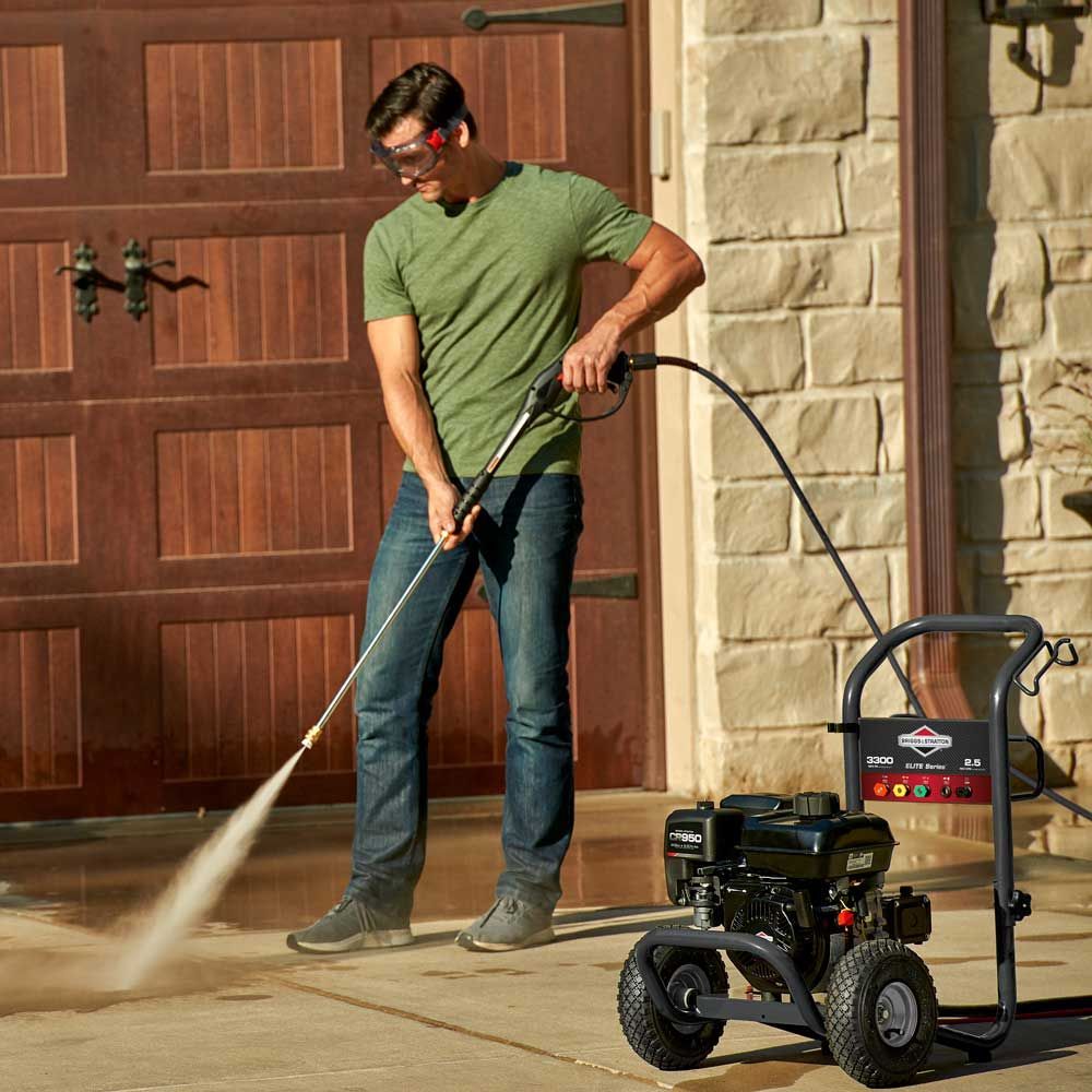 a man is using a high pressure washer on a driveway