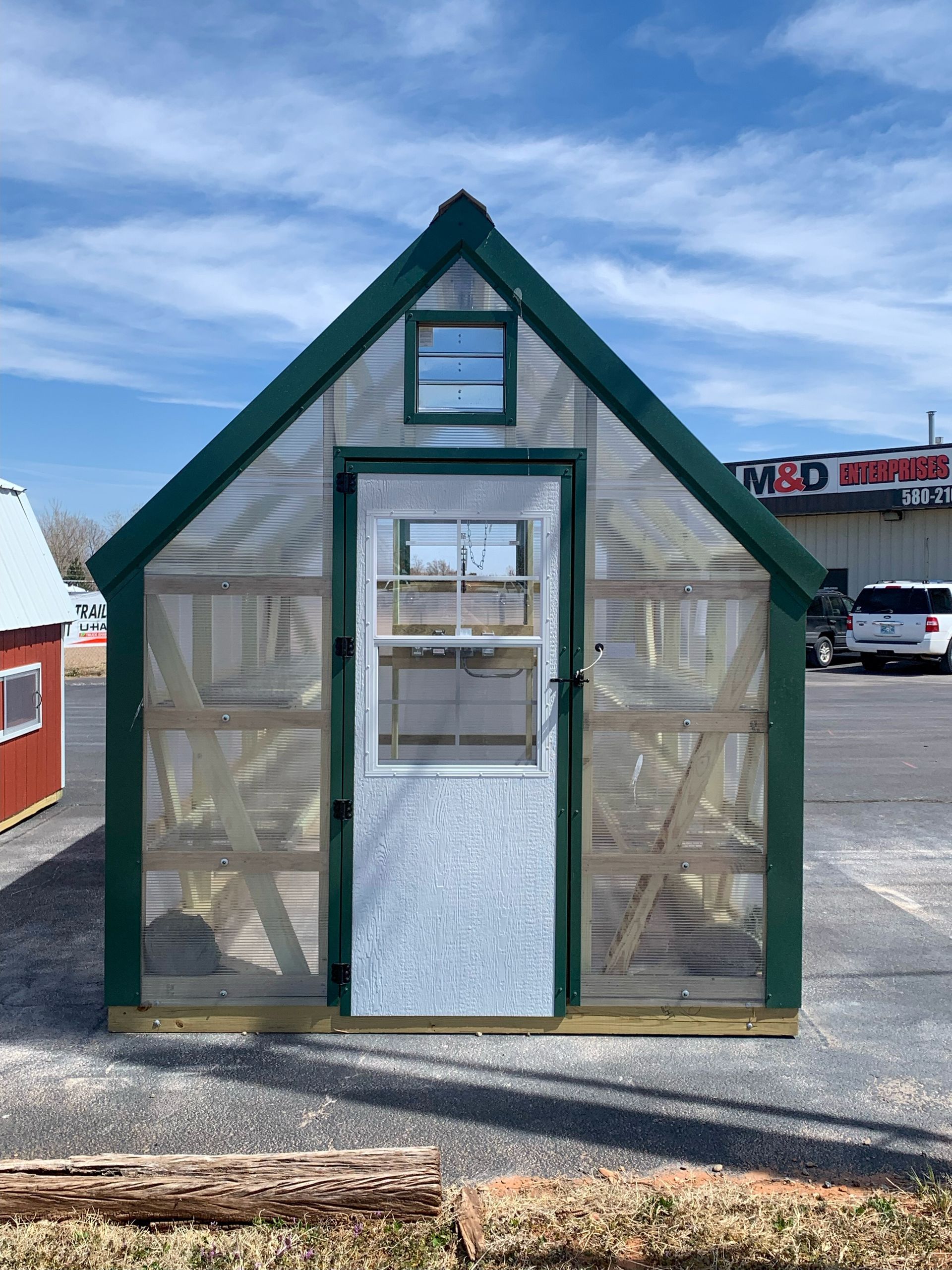 a 8 x 12 greenhouse in front of a m & d hardware store