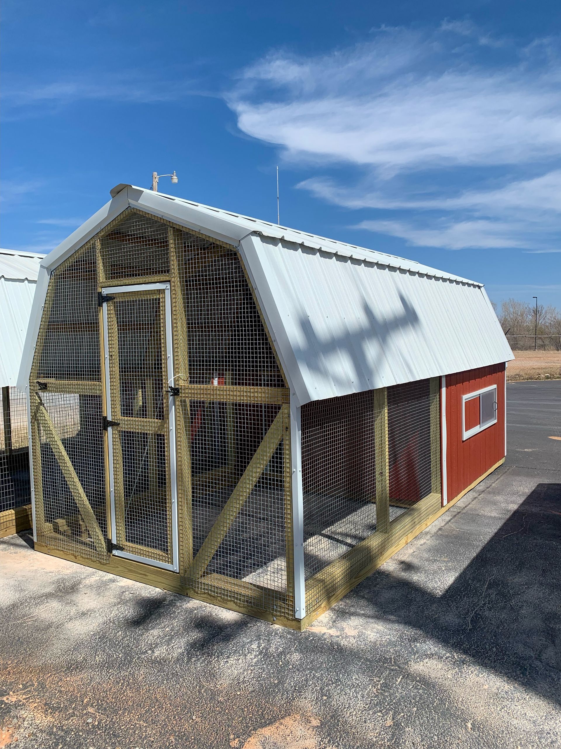 a red and white 8 x 16 chicken coop with a white roof