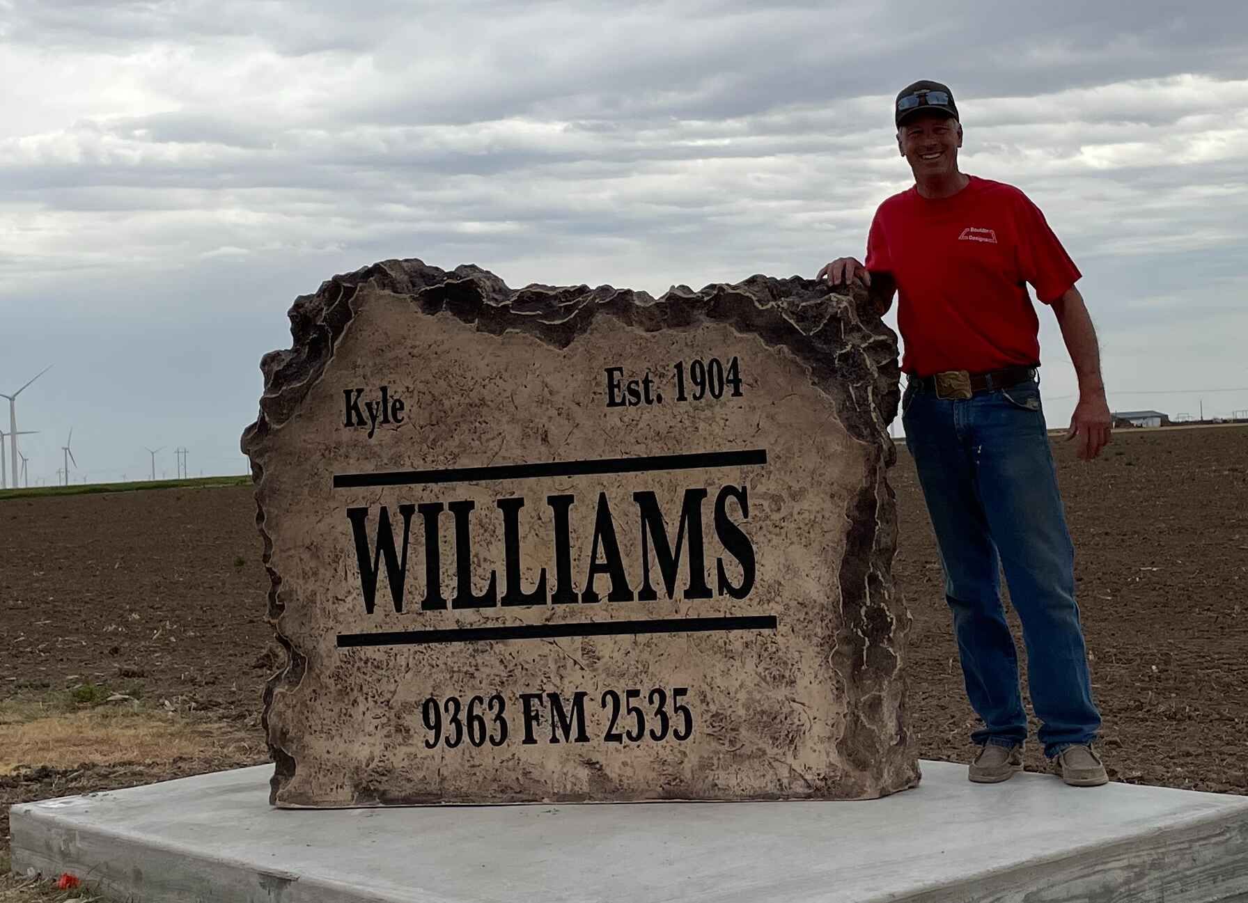 a man stands in front of a large williams sign 
