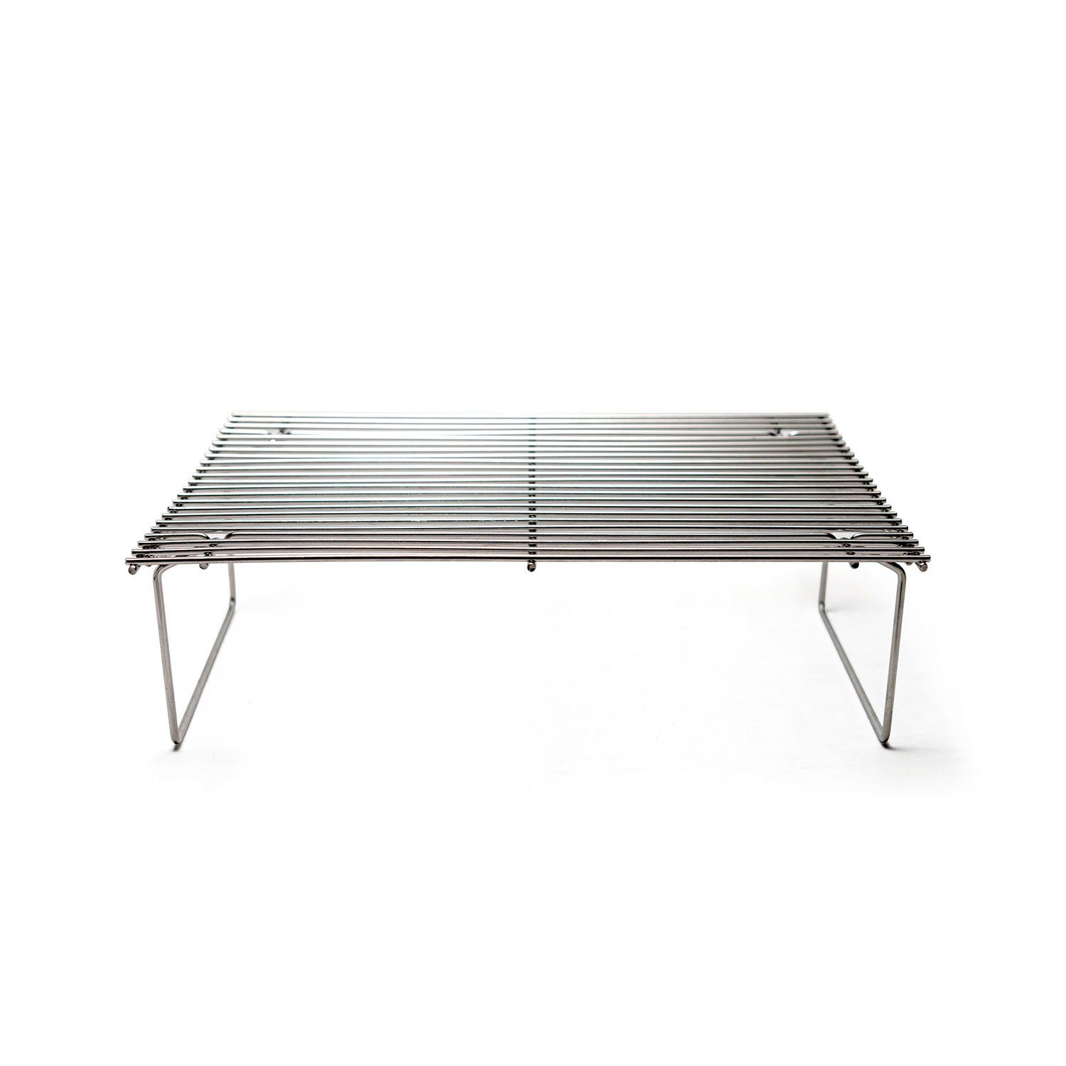 a stainless steel grill sits on a white surface