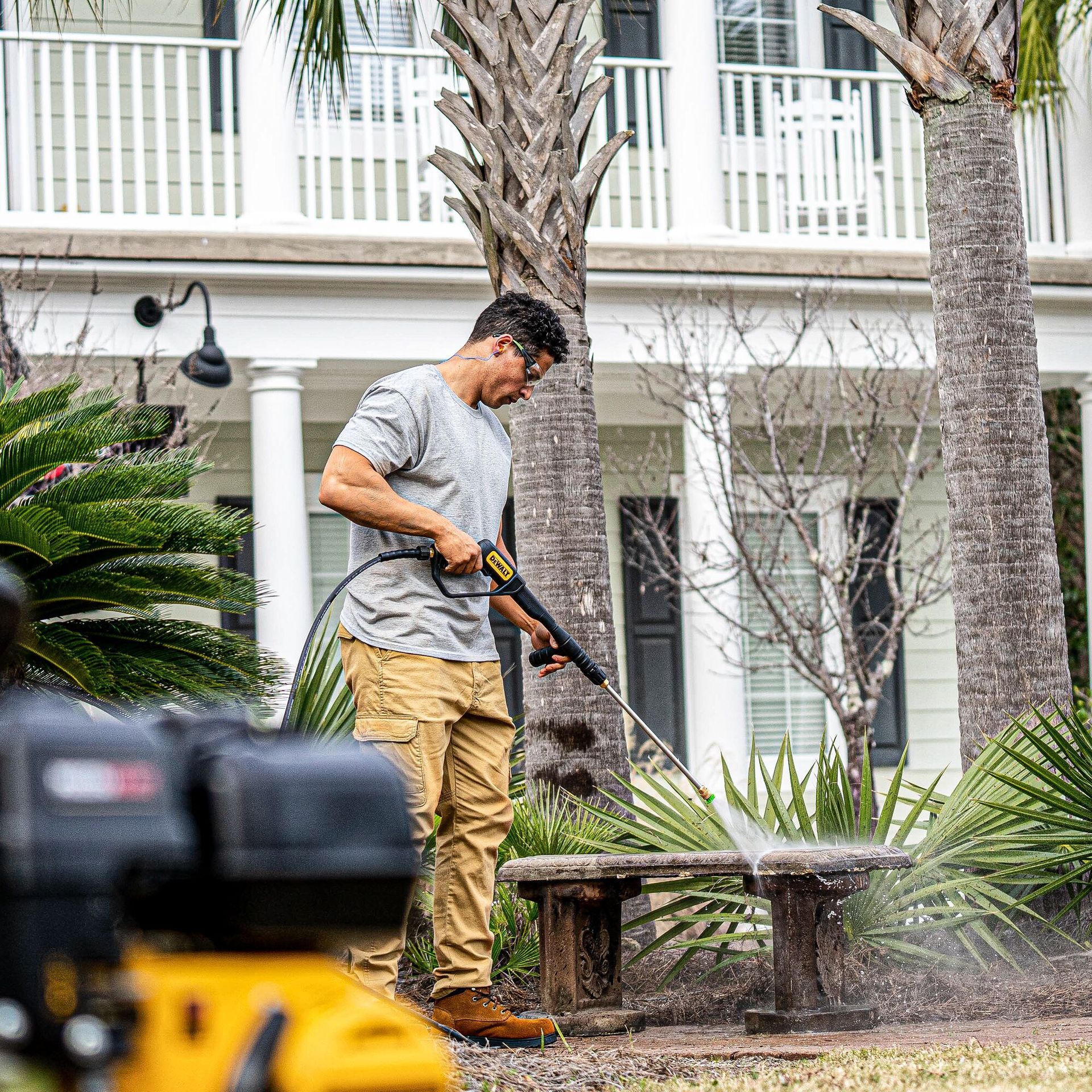 a man is using a high pressure washer in front of a house