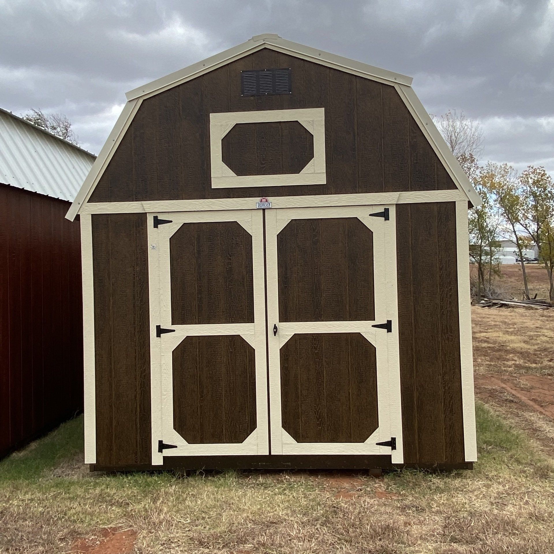 A brown and white barn shed with a white door