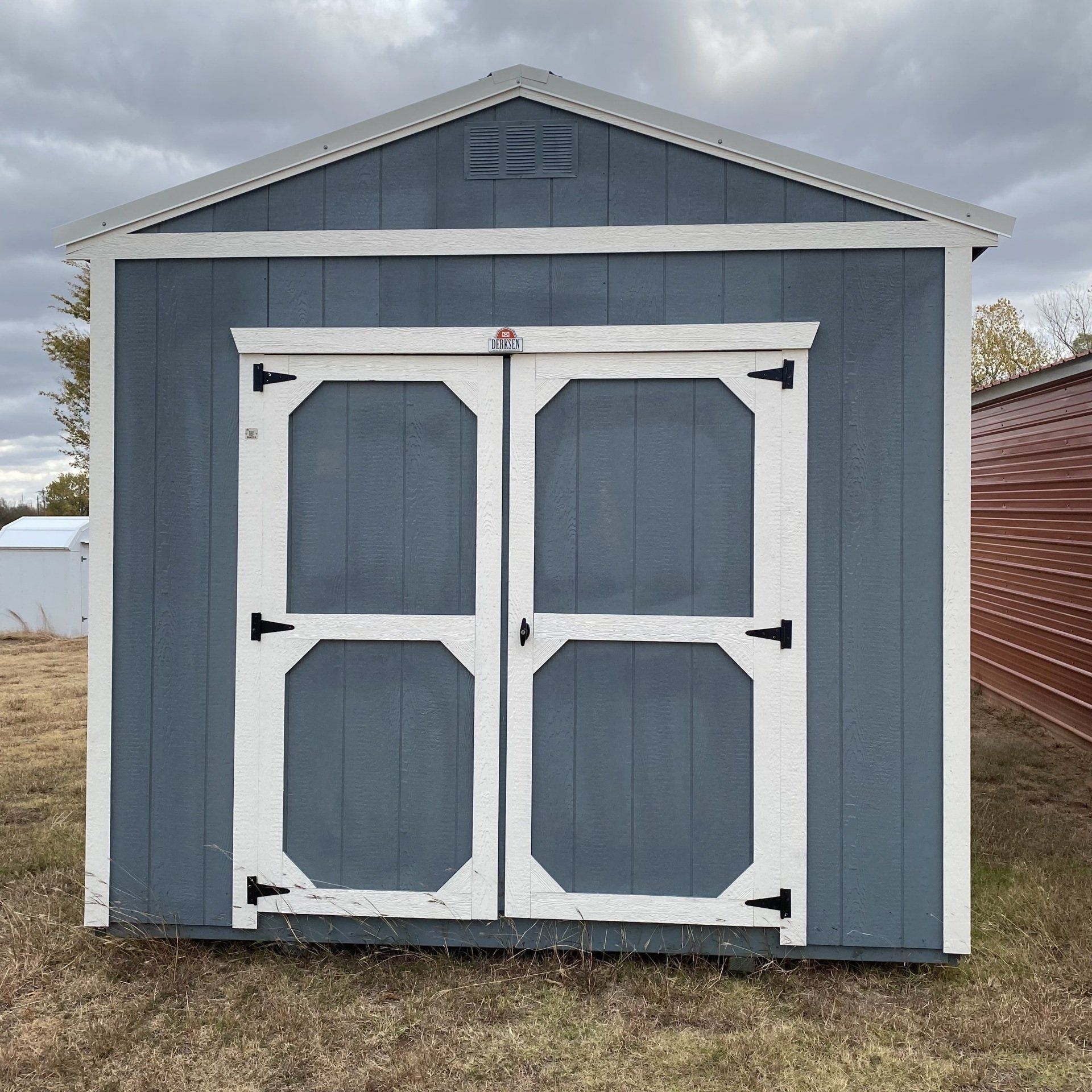 A blue and white shed with the doors open