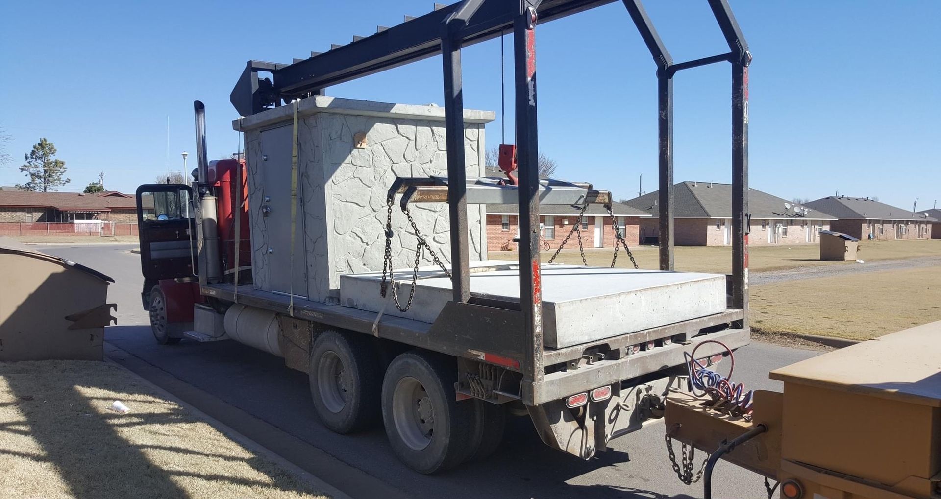a truck is carrying a large concrete safe room on the back of it
