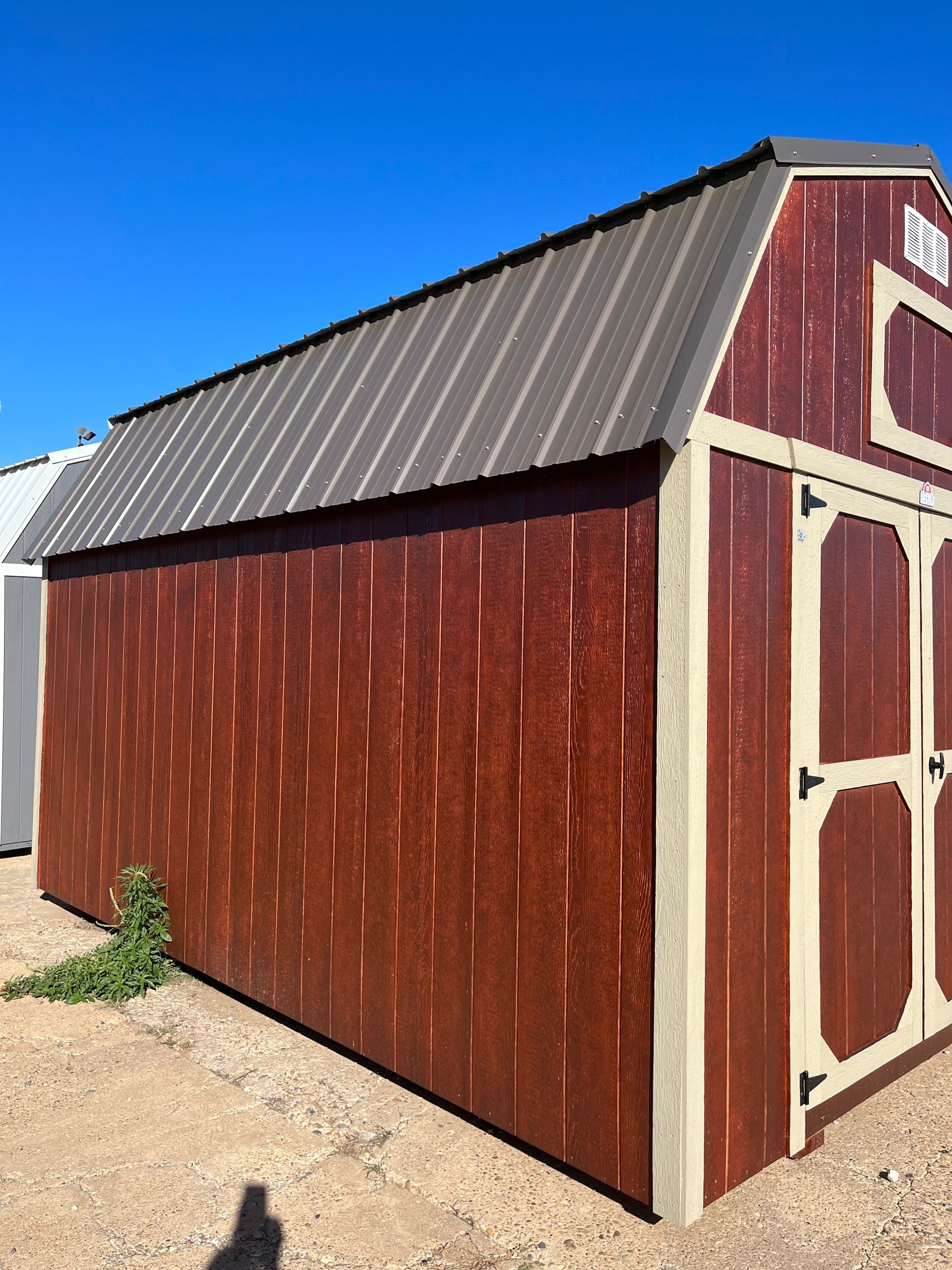 A red barn with a metal roof and white doors