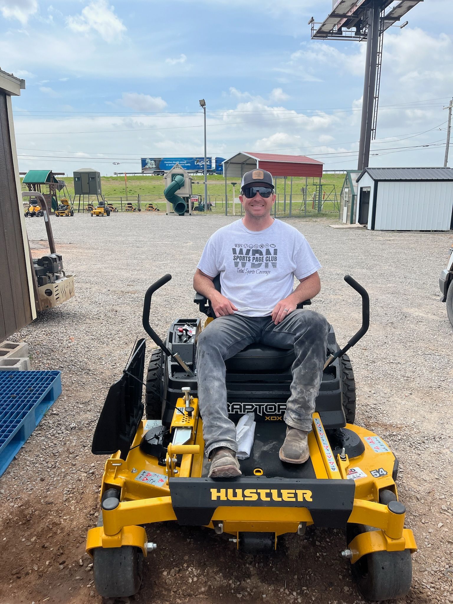 A man is sitting on a yellow lawn mower.