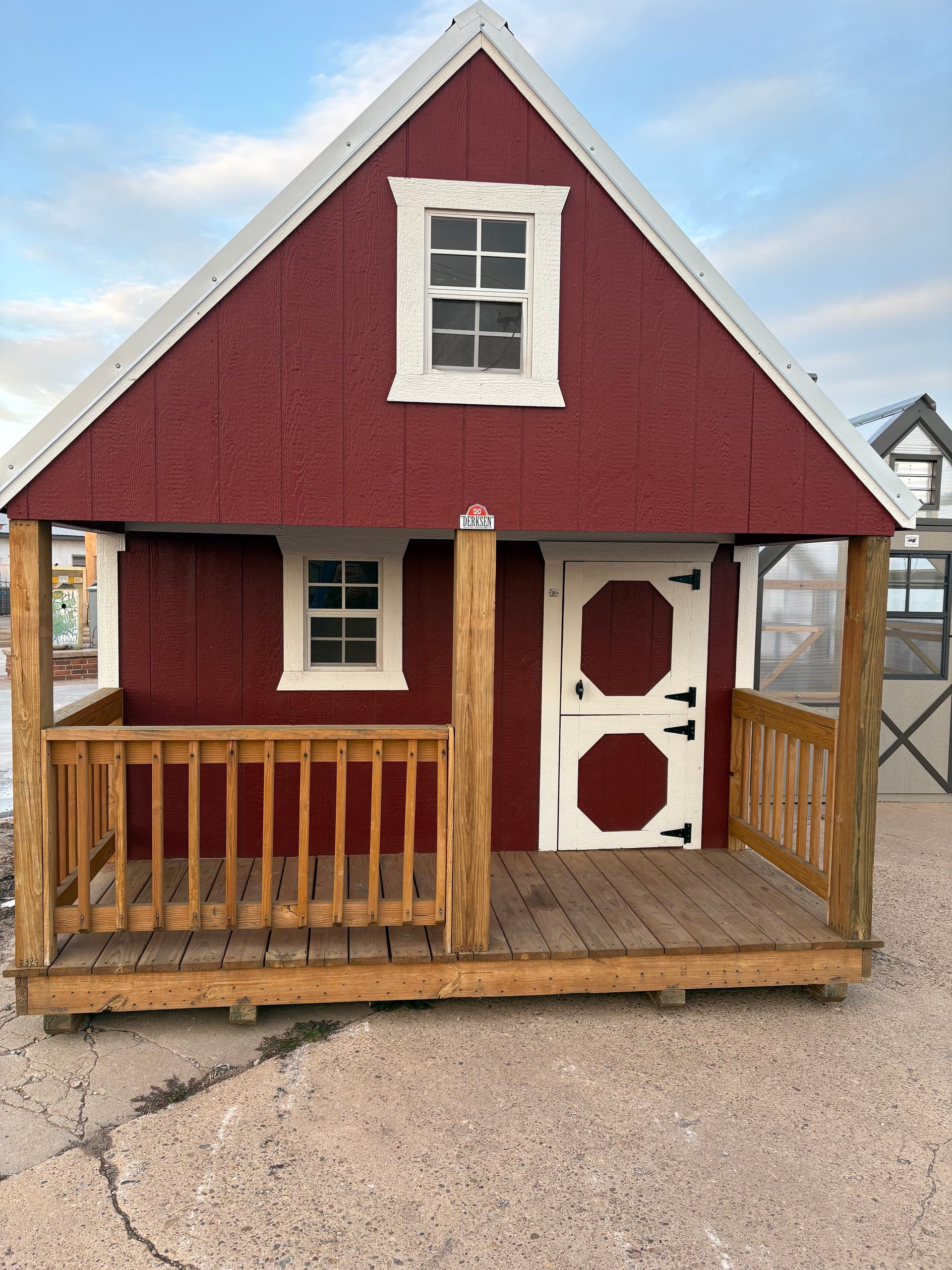 A small shed with a white roof and two windows