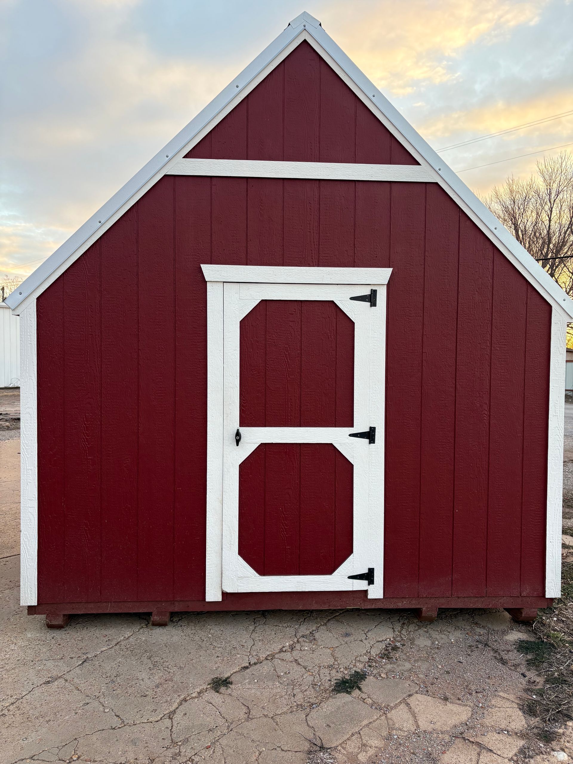 A red barn with a white door and a white roof