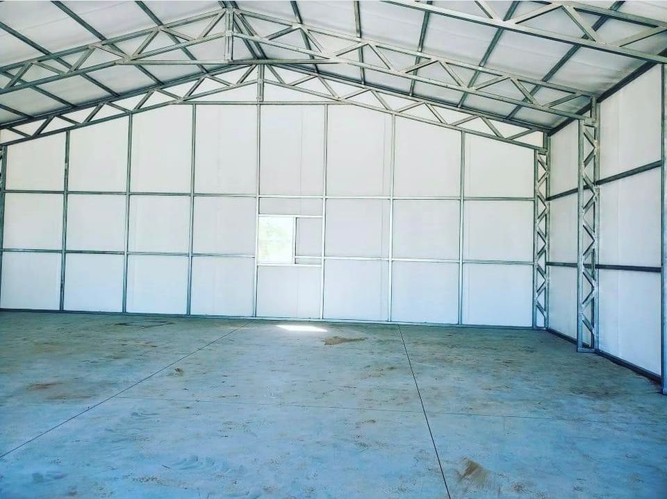 the inside of a garage with a metal frame and white walls .