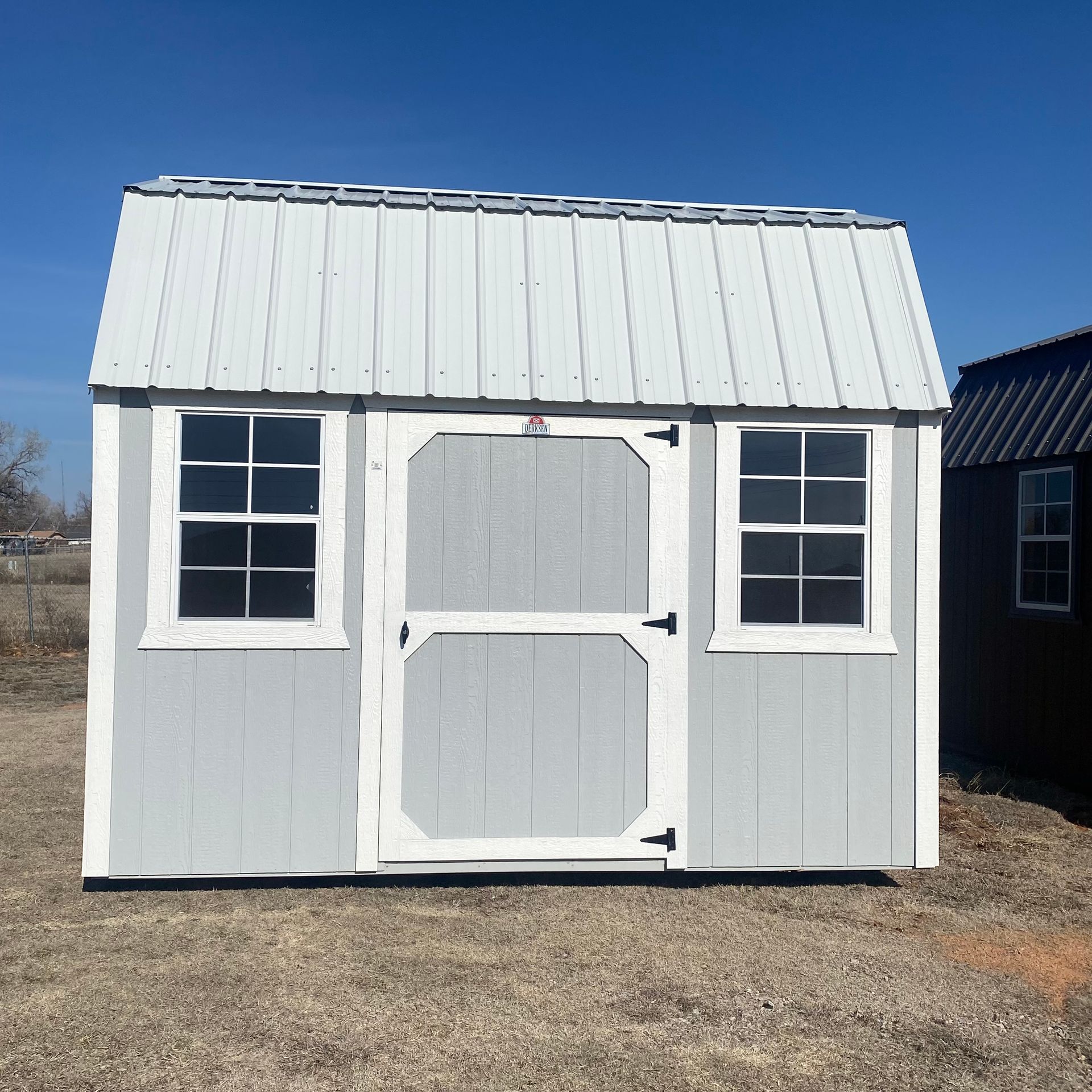 a small white shed with a white door and windows 8x12