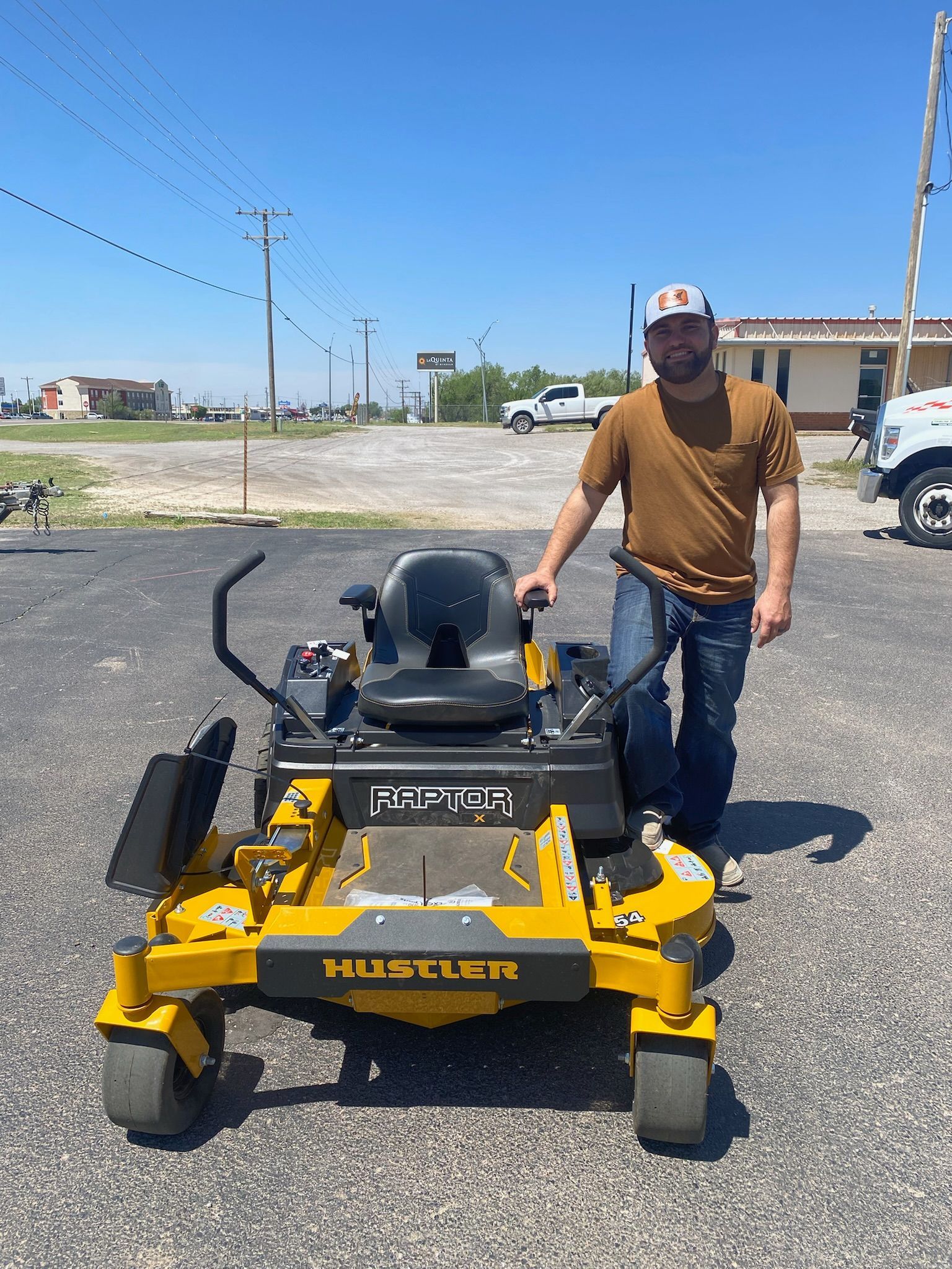 A man is standing next to a yellow and black lawn mower.