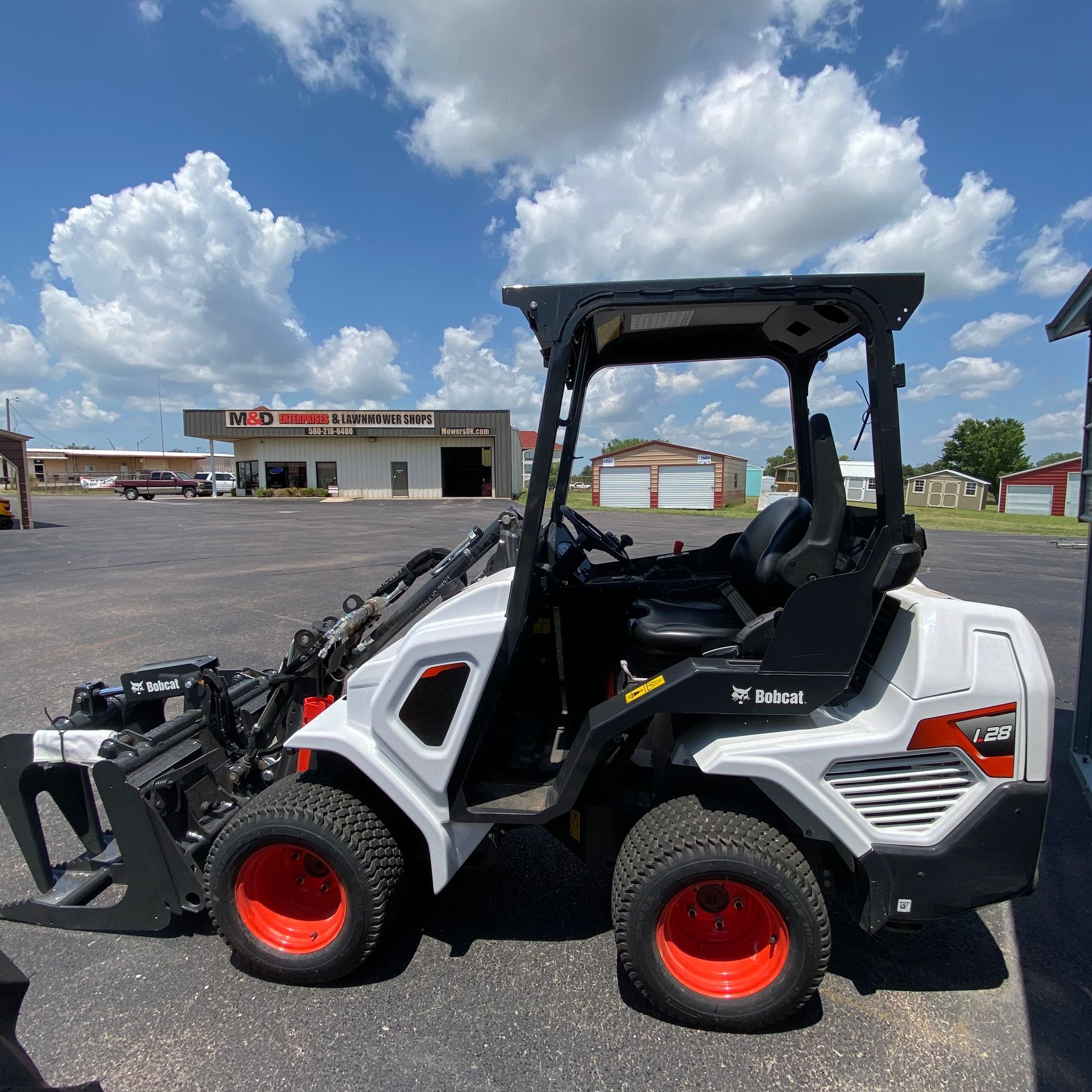 A bobcat tractor is parked in a parking lot