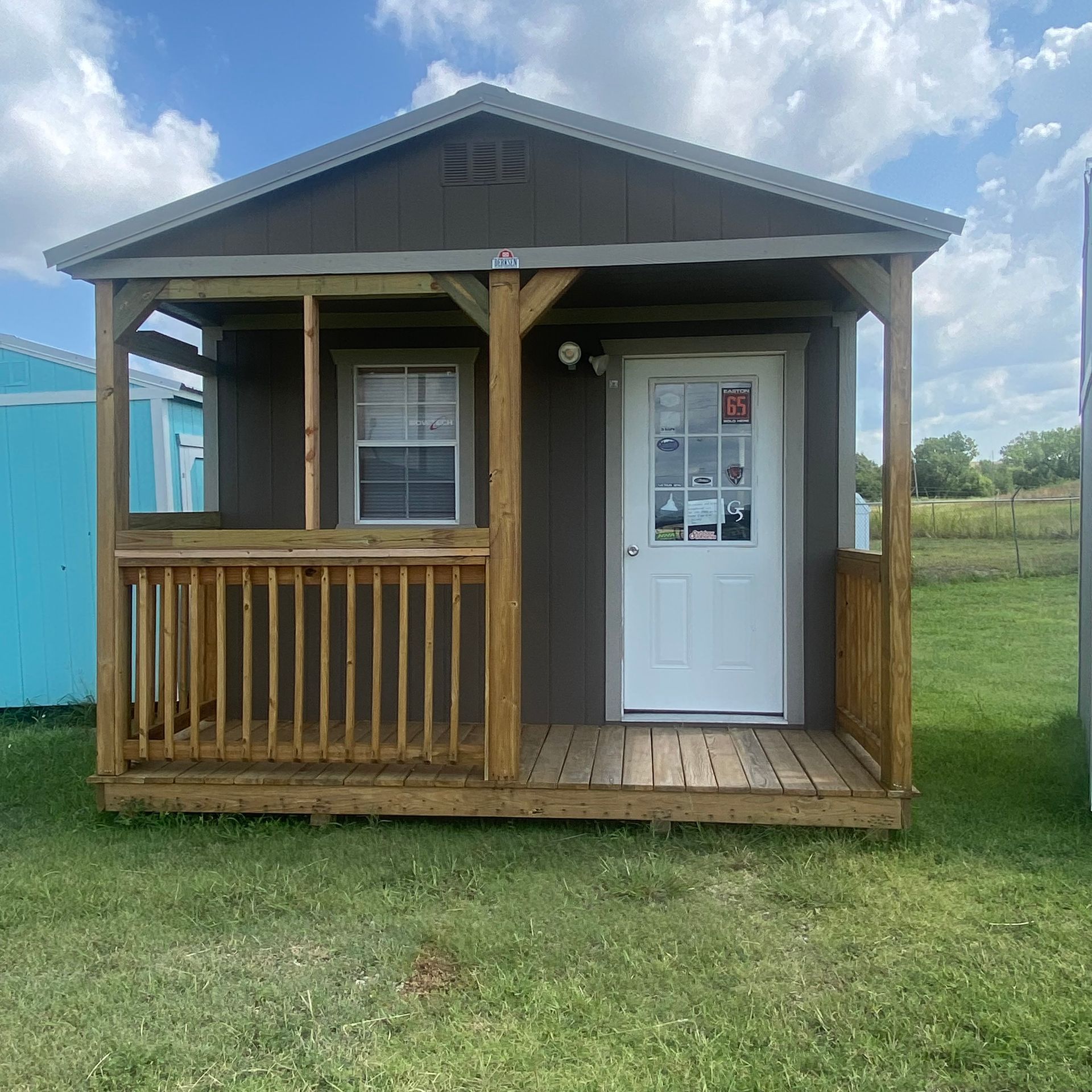 A small cabin with a porch and a white door