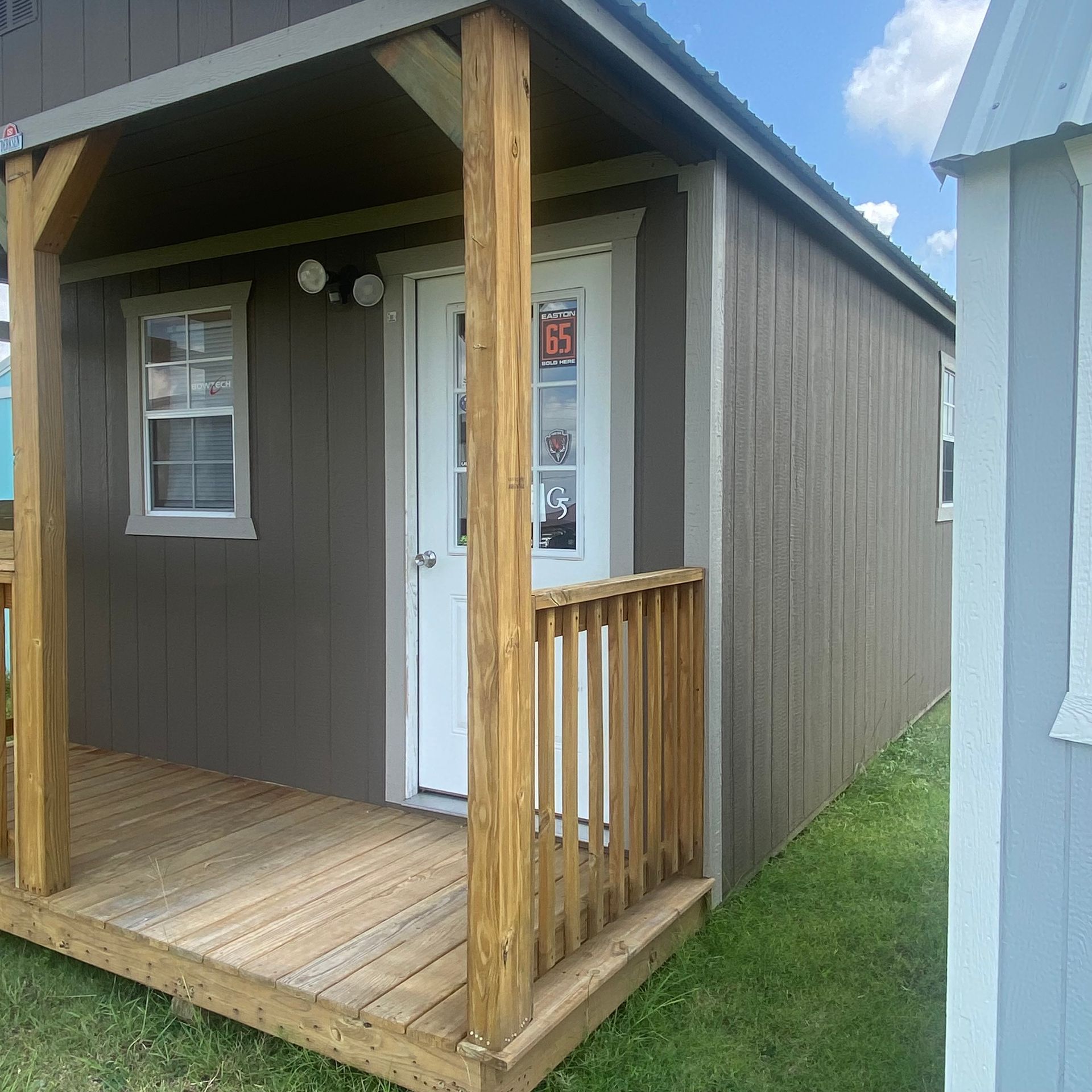 A small cabin with a porch and a sign that says open