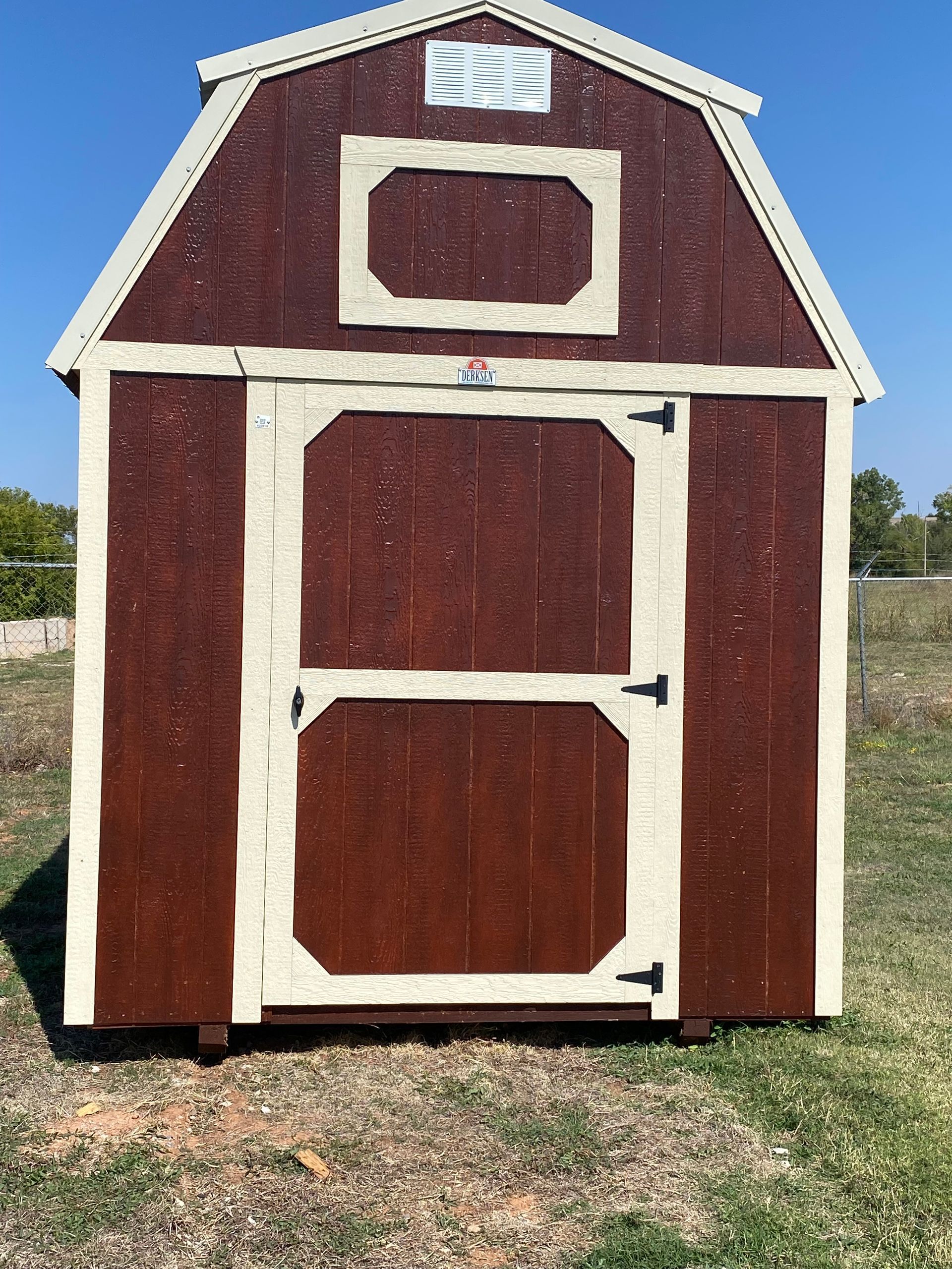 A Ash Gray shed with a Charcoal roof and Charcoal Trim is sitting in the middle of a grassy field.