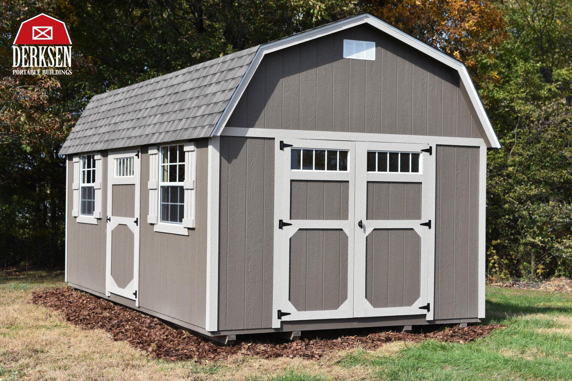 A deluxe shed is sitting in the middle of a grassy field